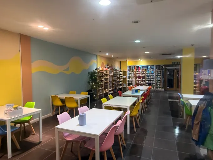 The Pictura café and studio with pastel walls, white tables and pink chairs
