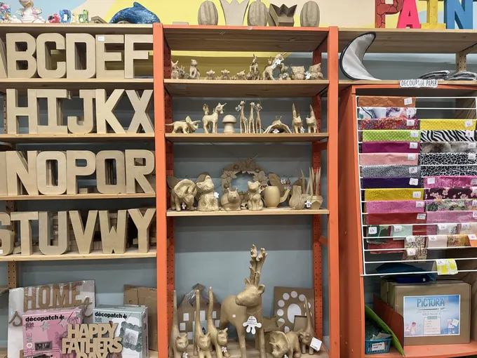 Shelves of papier-mâché letters and decoupage supplies in the Pictura studio