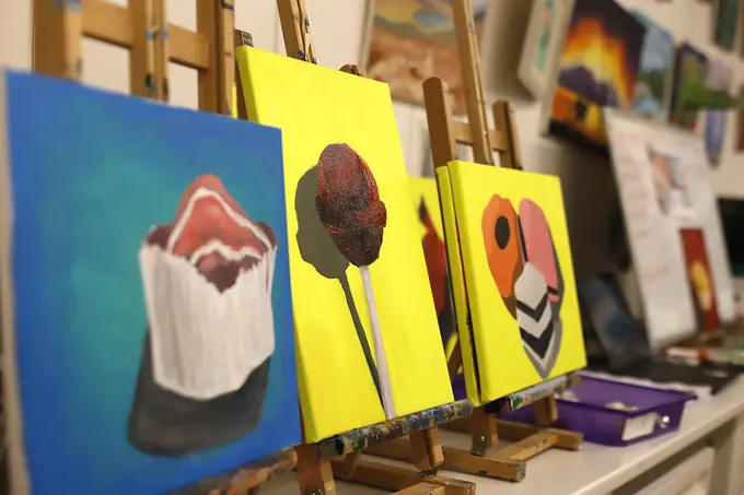 Finished canvas paintings on easels after a painting session