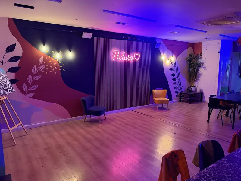 The Pictura events room with the pink Pictura neon sign and purple lighting