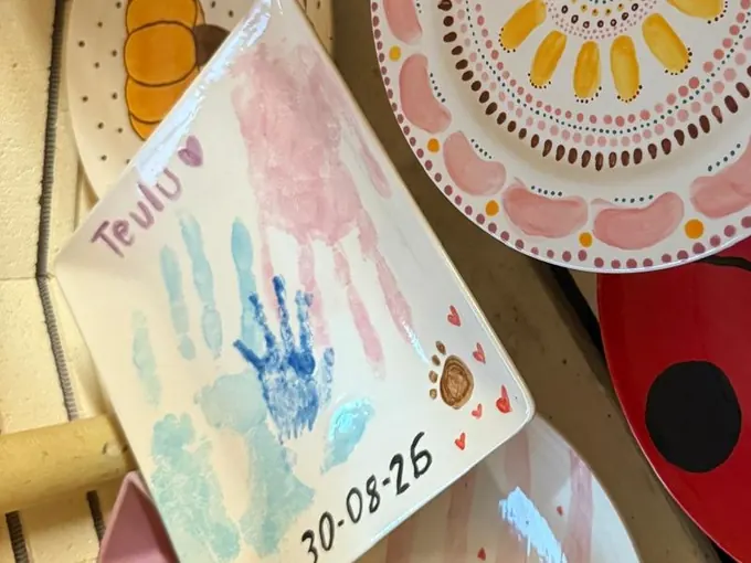 A glazed pottery keepsake with a child’s handprints, fresh from the kiln