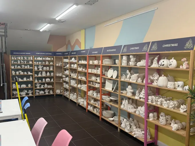 Shelves of plain pottery waiting to be painted in the Pictura studio